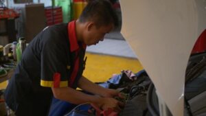 Seorang teknisi dokter mobil sedang cek kerusakan