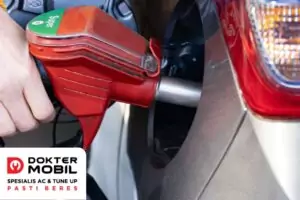 mengisi bahan bakar di pom bensin terdekat